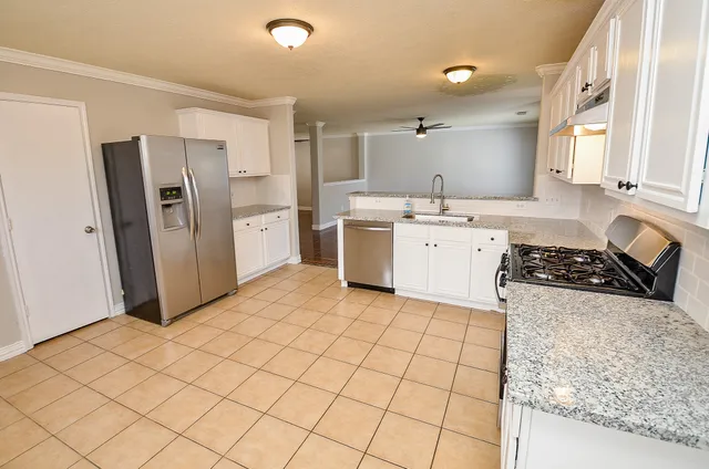 a kitchen with a sink a stove a refrigerator and cabinets