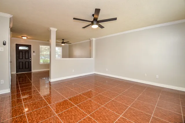 en empty room with wooden floor and a ceiling fan