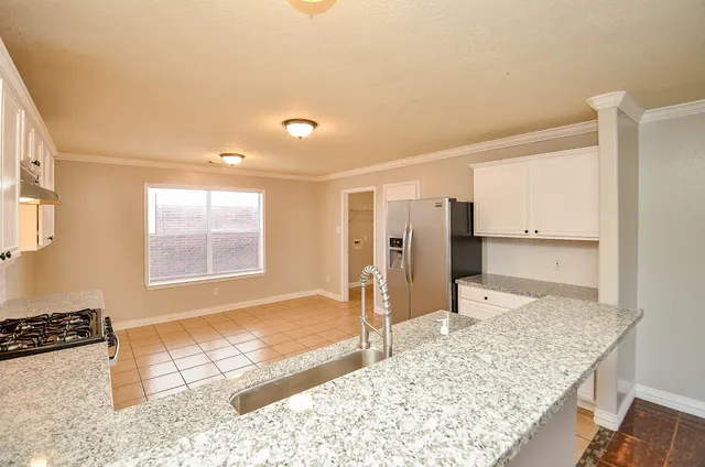 a view of a kitchen with a stove top oven and cabinets