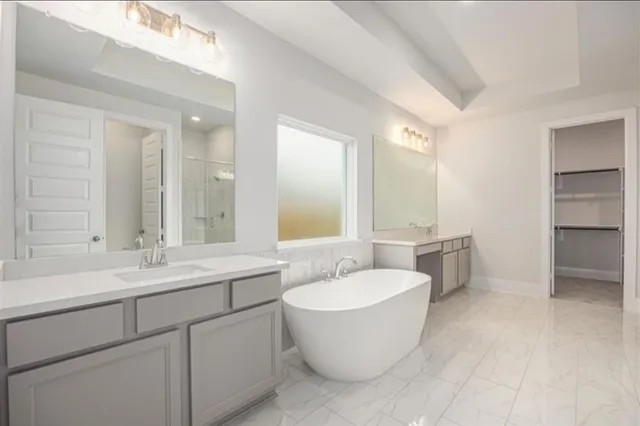 a spacious bathroom with a double vanity sink mirror and bathtub