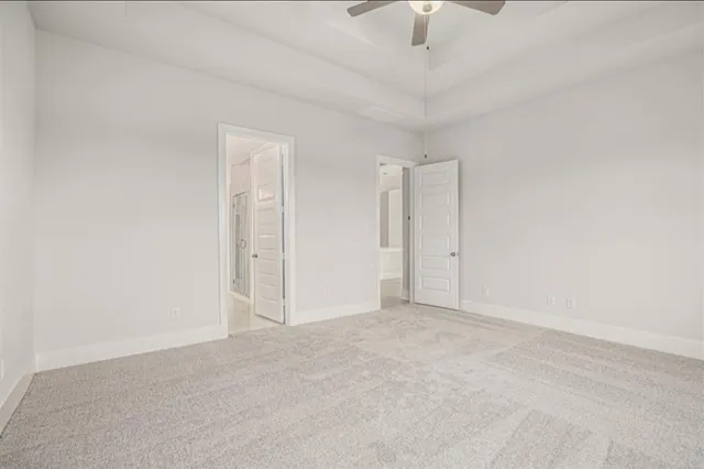 an empty room with a ceiling fan and a window