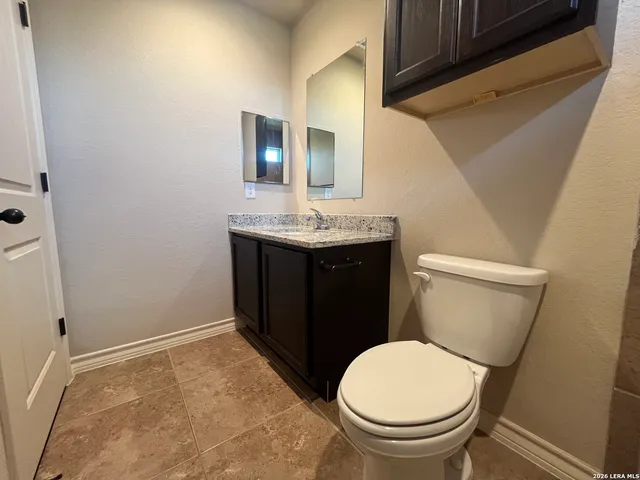 a bathroom with a toilet a sink and mirror