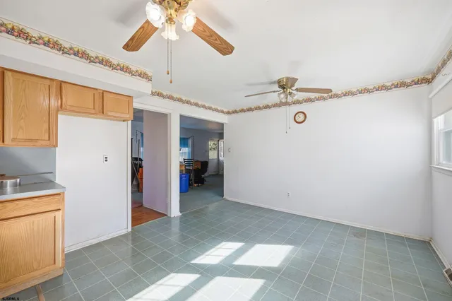 a view of a livingroom with a ceiling fan & a window