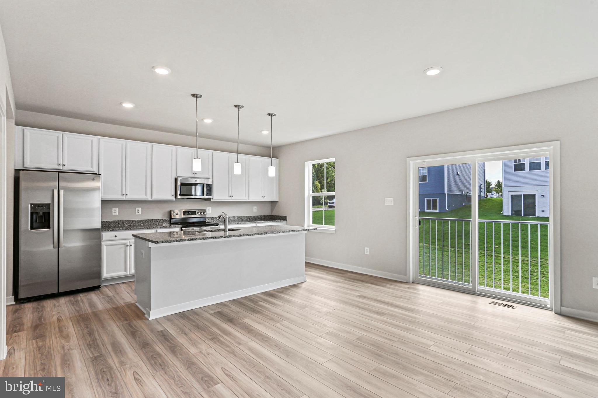 Shenandoah Springs, Unit PRIMROSE Ranson, WV 25438 - Photo 5 of 23 a kitchen with stainless steel appliances granite countertop a refrigerator a sink dishwasher a stove and white cabinets with wooden floor