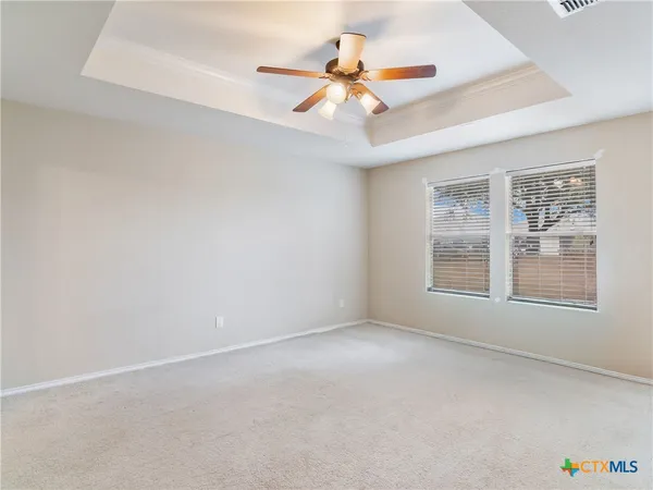 an empty room with a window and a fan