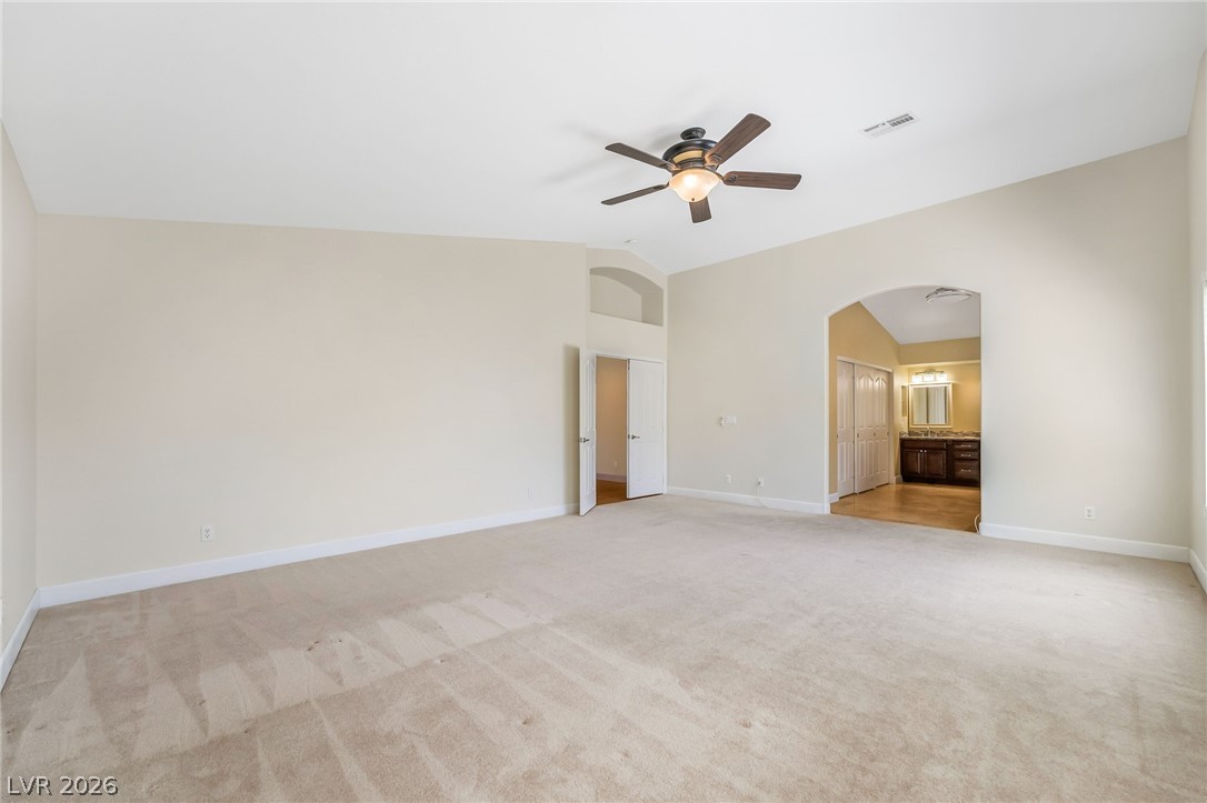 271 Pointe Ranier Avenue Henderson, NV 89012 - Photo 14 of 26 This primary bedroom offers a spacious layout with vaulted ceilings, creating an airy and open atmosphere.