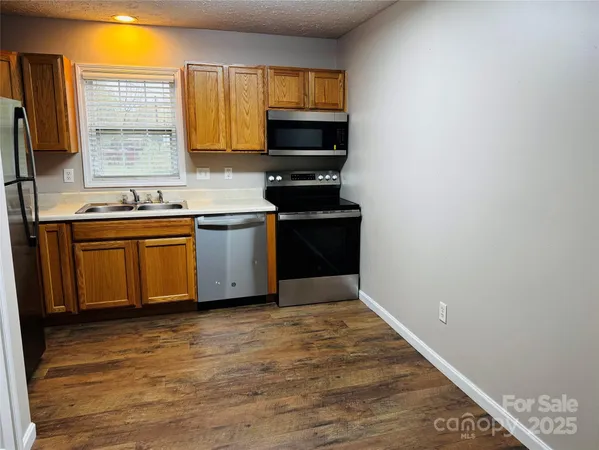 a kitchen with stainless steel appliances granite countertop a stove a sink and a microwave