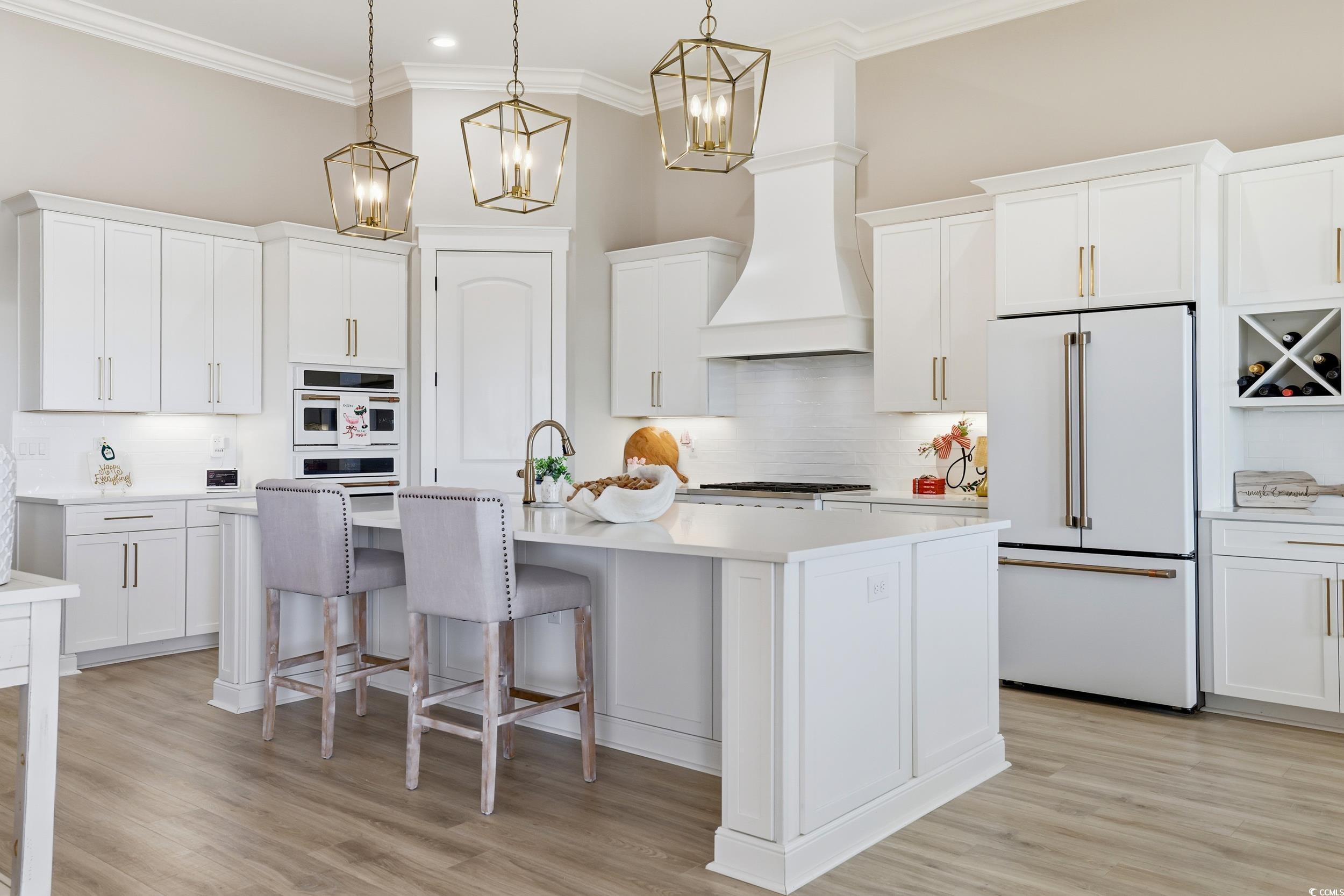 280 Bay Rdg Drive North Myrtle Beach, SC 29582 - Photo 12 of 38 Kitchen with white appliances, backsplash, white cabinets, a kitchen bar, and crown molding