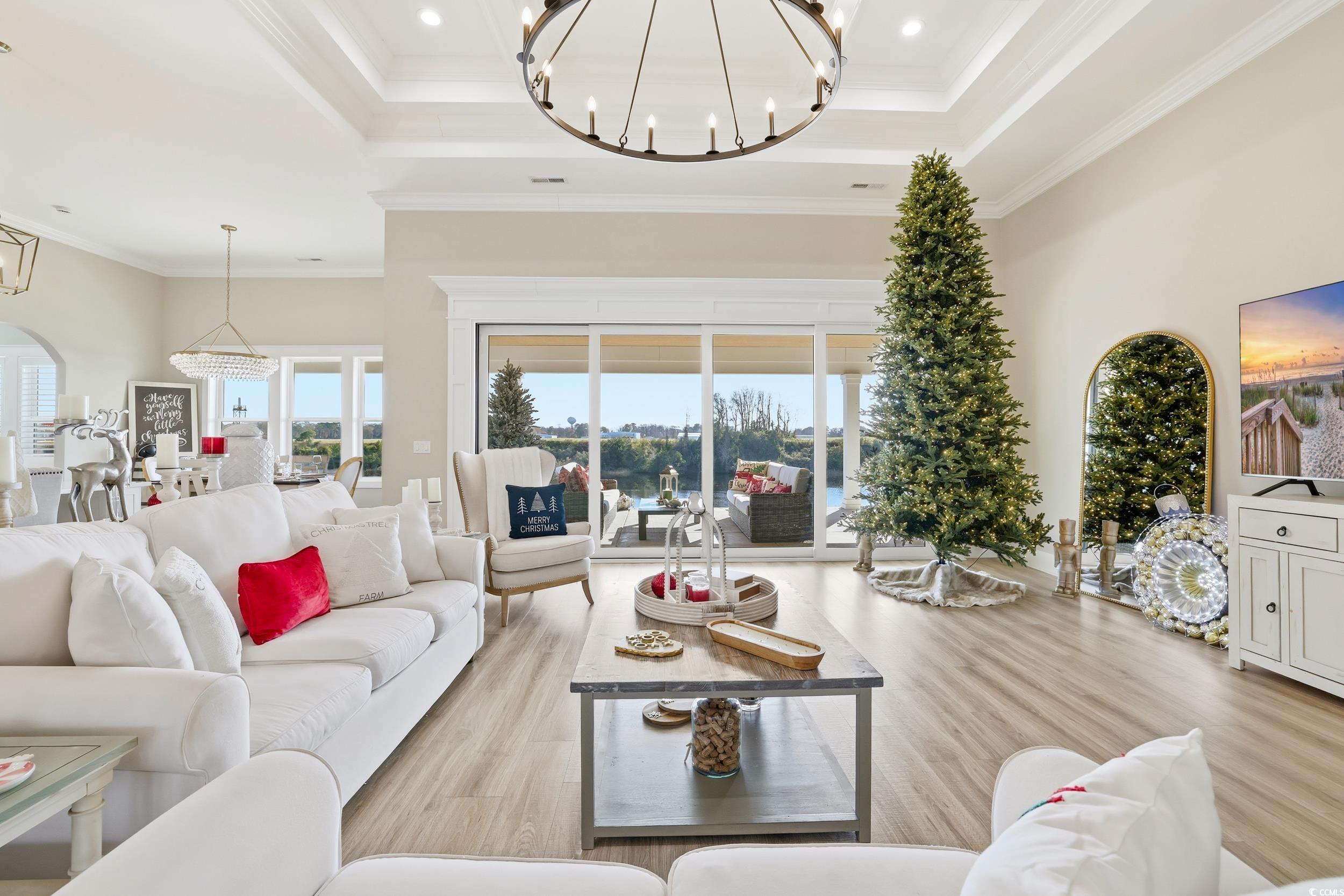280 Bay Rdg Drive North Myrtle Beach, SC 29582 - Photo 17 of 38 Living area featuring a chandelier, a raised ceiling, light wood-type flooring, ornamental molding, and a high ceiling