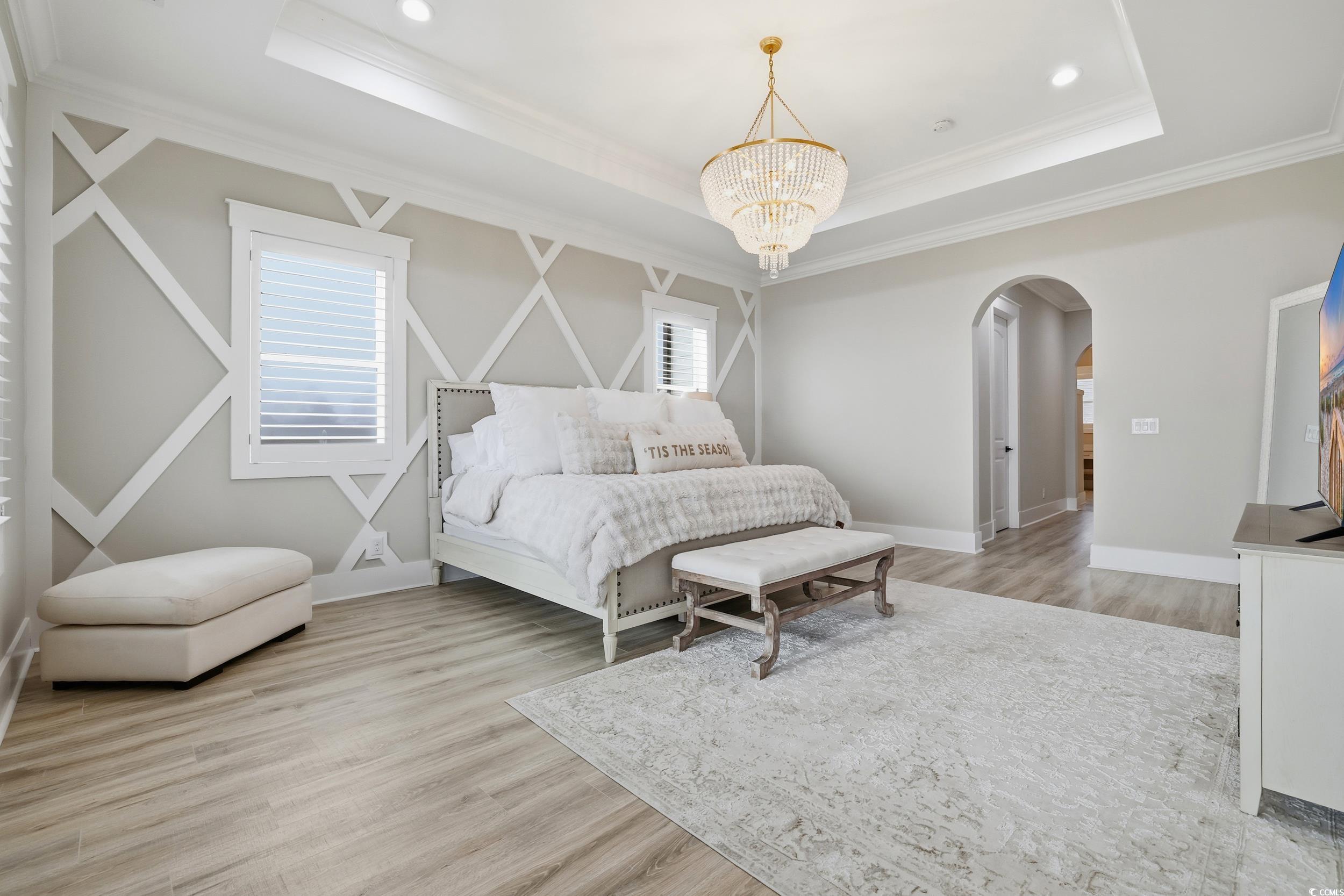 280 Bay Rdg Drive North Myrtle Beach, SC 29582 - Photo 18 of 38 Bedroom with light wood-type flooring, arched walkways, crown molding, a chandelier, and a raised ceiling