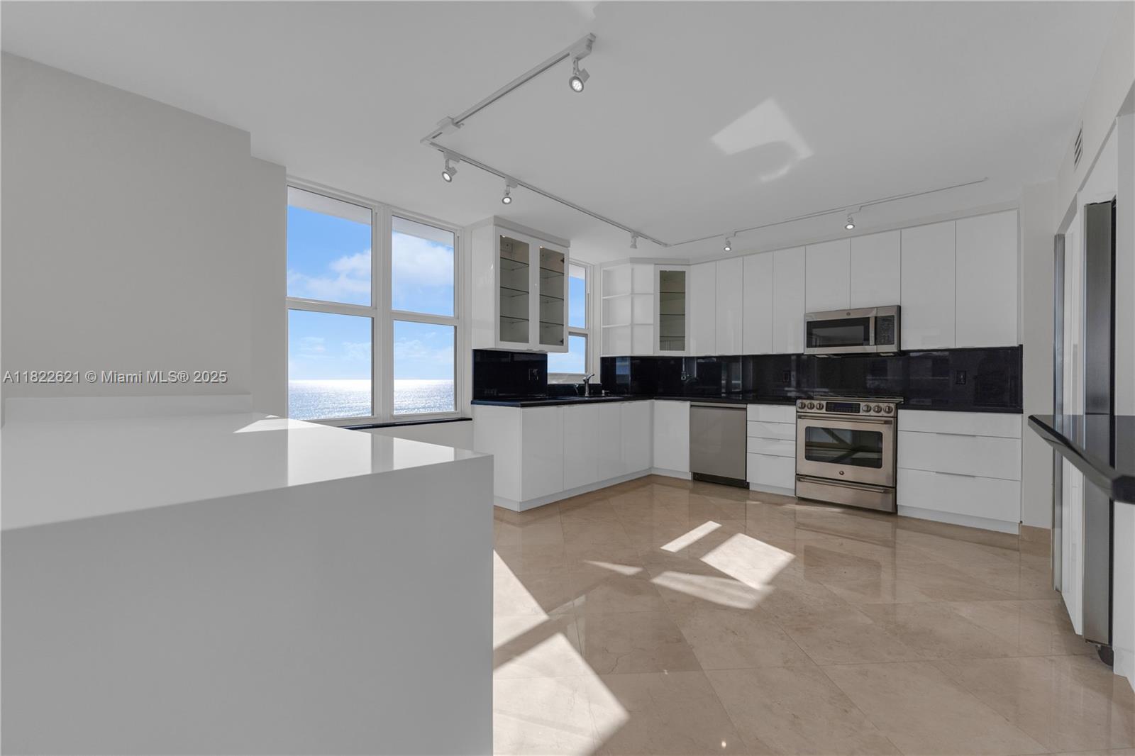 9801 Collins Avenue, Unit 16Y Bal Harbour, FL 33154 - Photo 4 of 17 a large white kitchen with stainless steel appliances granite countertop a stove and a sink