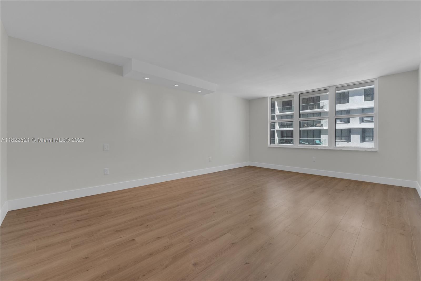 9801 Collins Avenue, Unit 16Y Bal Harbour, FL 33154 - Photo 6 of 17 a view of an empty room with a window and wooden floor