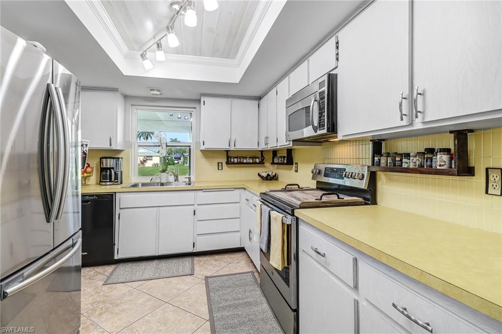 4576 Eagle Key Circle Naples, FL 34112 - Photo 11 of 18 a kitchen with stainless steel appliances granite countertop a sink a stove a refrigerator and cabinets