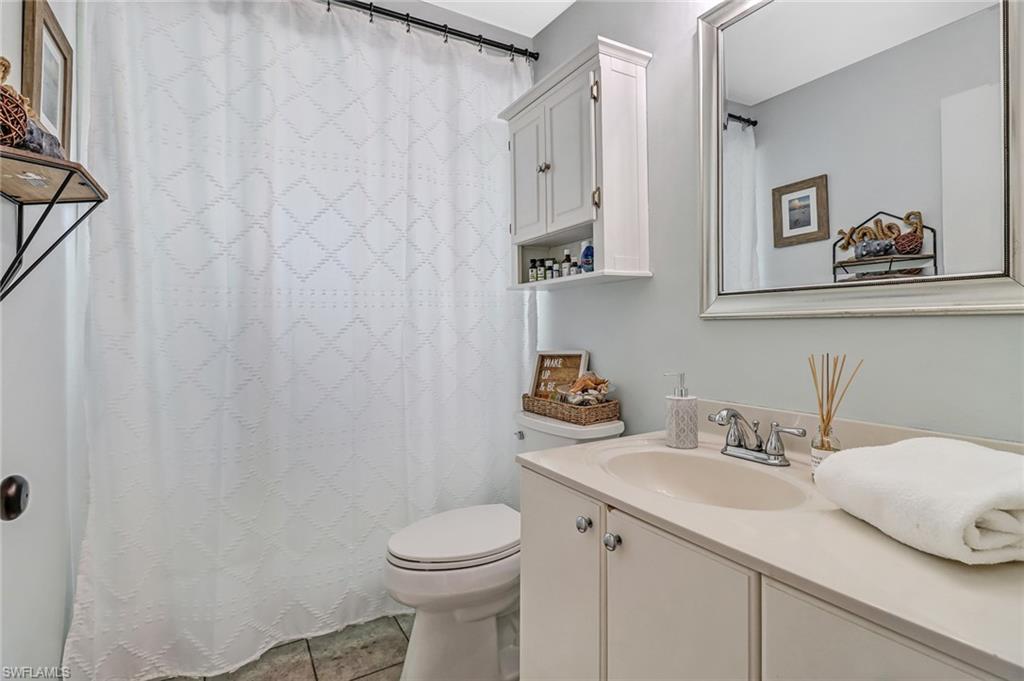 4576 Eagle Key Circle Naples, FL 34112 - Photo 14 of 18 a bathroom with a toilet sink and mirror