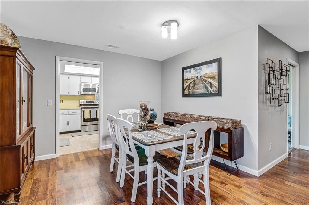 4576 Eagle Key Circle Naples, FL 34112 - Photo 9 of 18 a view of a dining room with furniture and wooden floor