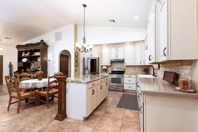 a kitchen with stainless steel appliances kitchen island granite countertop a stove and cabinets