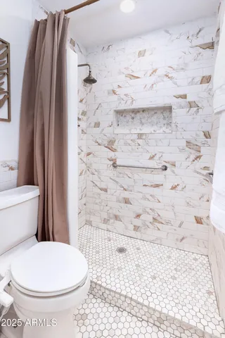 a bathroom with a toilet and a shower