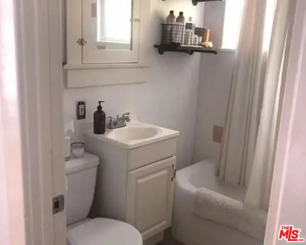 a bathroom with a sink toilet and window