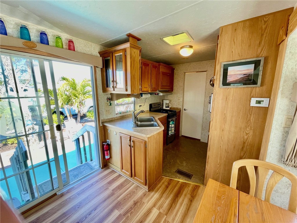 5288 Inlet Way Hutchinson Island, FL 34949 - Photo 12 of 21 a kitchen with refrigerator a stove a sink dishwasher and wooden cabinets
