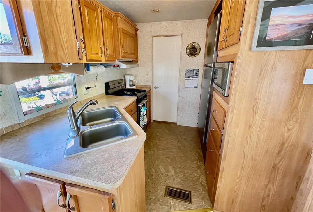 5288 Inlet Way Hutchinson Island, FL 34949 - Photo 15 of 21 a kitchen with stainless steel appliances granite countertop a refrigerator a stove and a sink with wooden floor