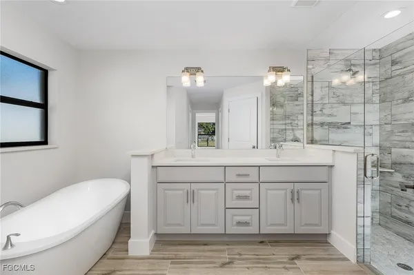 a bathroom with a granite countertop sink a toilet a mirror and shower