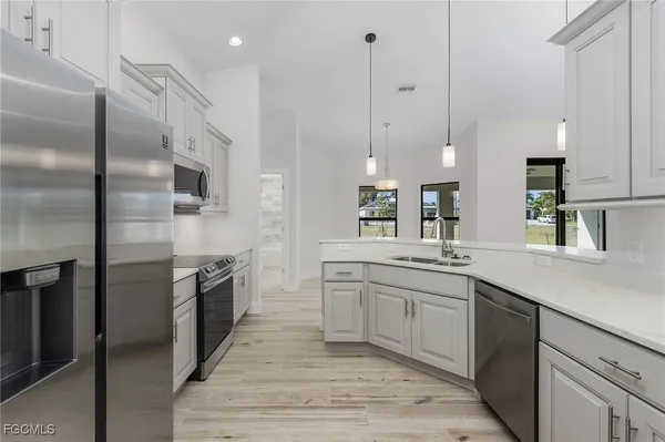 a large kitchen with stainless steel appliances kitchen island granite countertop a sink a stove and a refrigerator