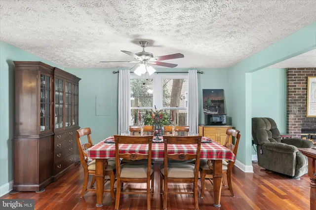 a dining room with furniture a chandelier and wooden floor
