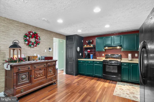 a kitchen with stainless steel appliances granite countertop a refrigerator stove and sink