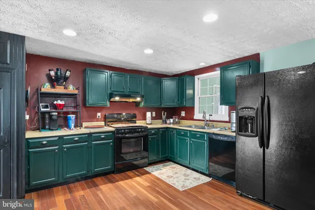 a kitchen with kitchen island stainless steel appliances a sink stove and refrigerator