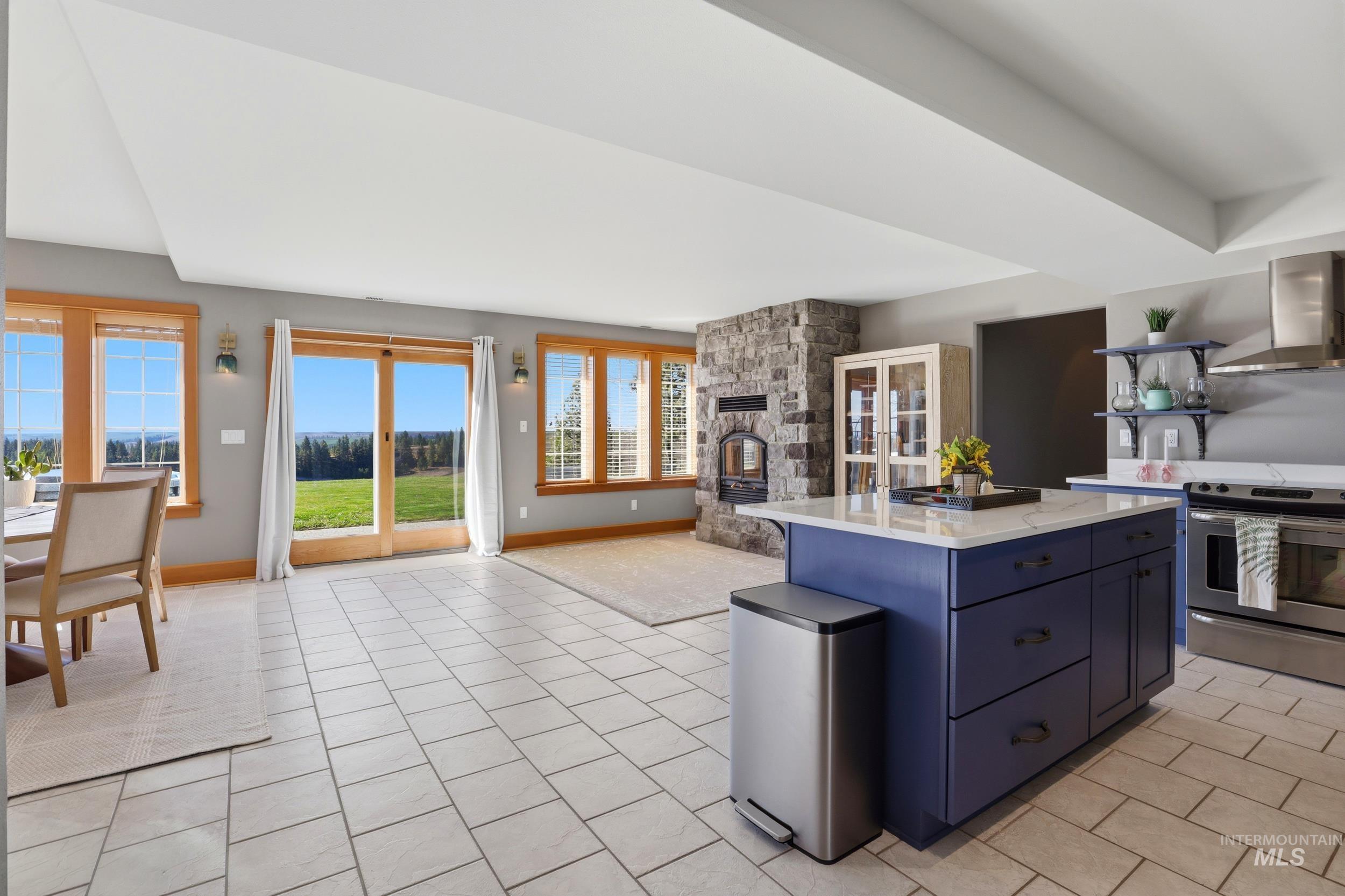 1014 Hilby Road Moscow, ID 83843 - Photo 50 of 50 Kitchen with electric stove, open floor plan, blue cabinetry, a kitchen island, and a fireplace