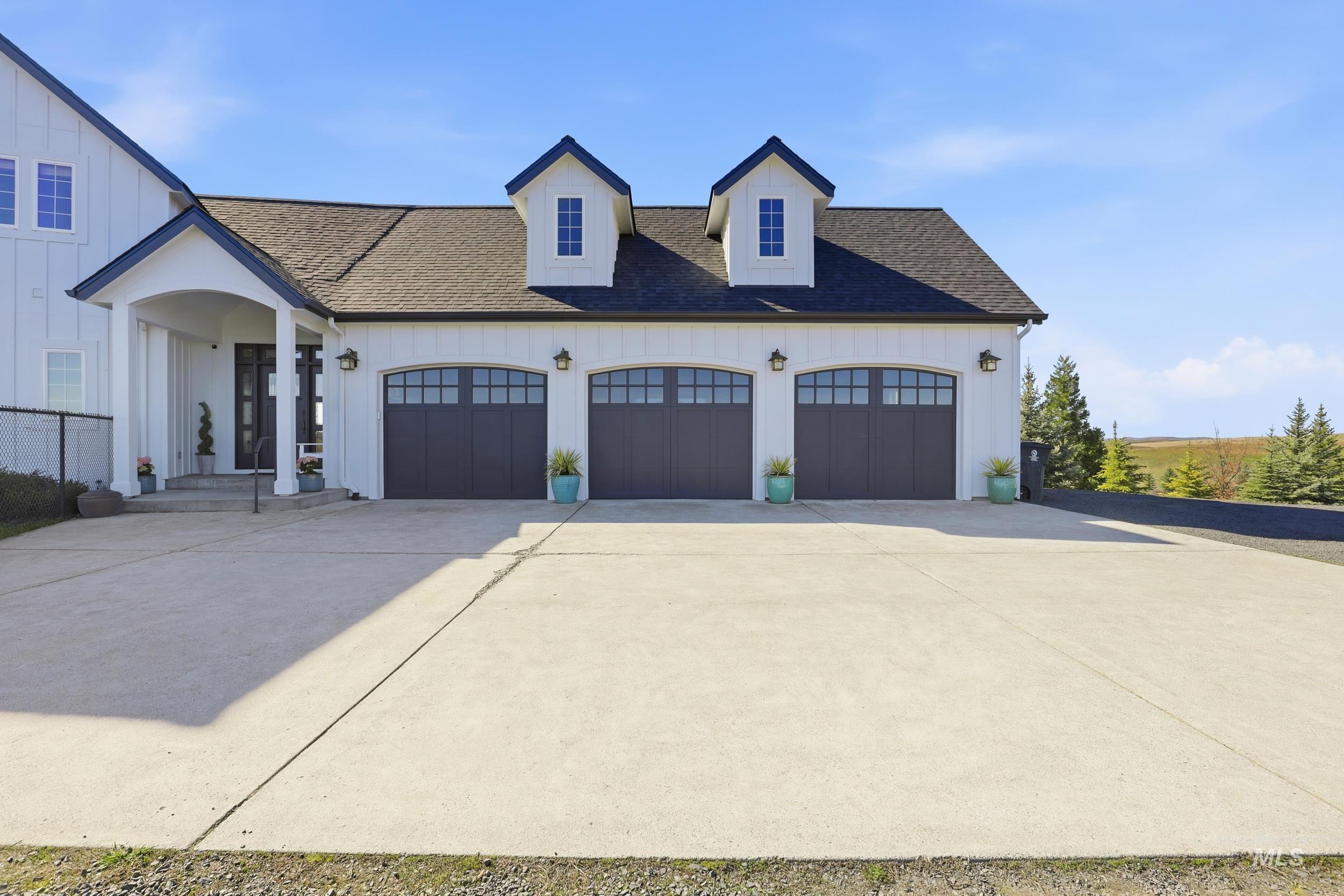 1014 Hilby Road Moscow, ID 83843 - Photo 5 of 50 View of front of house with board and batten siding, driveway, roof with shingles, and a garage