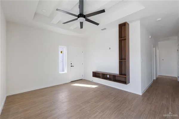 an empty room with fan and windows