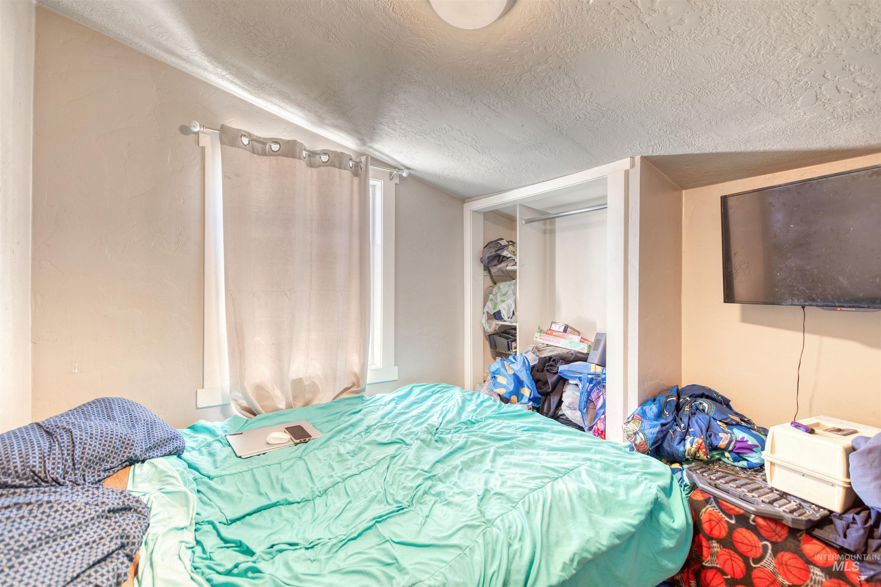 108 East Main Street Nyssa, OR 97913 - Photo 14 of 19 Bedroom featuring a textured ceiling and a closet