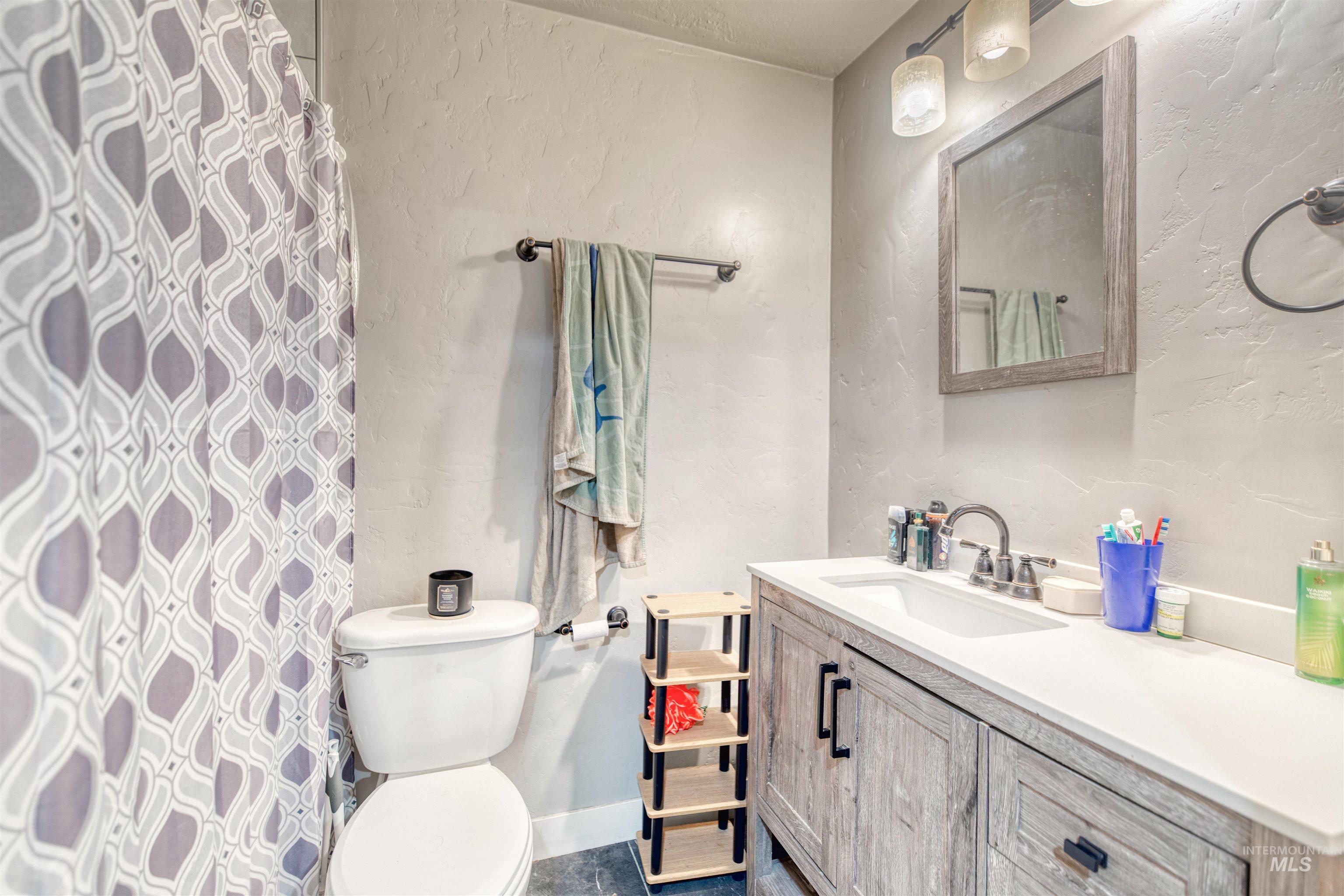 108 East Main Street Nyssa, OR 97913 - Photo 17 of 19 Full bath featuring vanity, a textured wall, and curtained shower