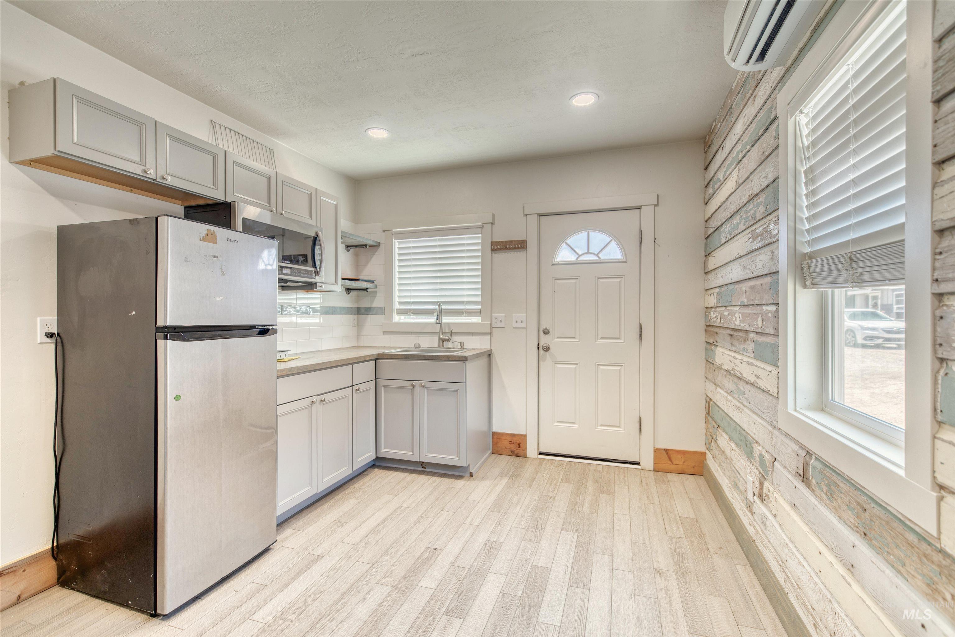 108 East Main Street Nyssa, OR 97913 - Photo 6 of 19 Kitchen with appliances with stainless steel finishes, healthy amount of natural light, an AC wall unit, light countertops, and recessed lighting