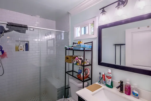 a bathroom with a sink vanity and a shower