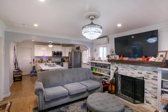 a living room with furniture a flat screen tv and a fireplace