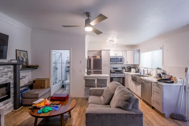 a living room with furniture kitchen view and a fireplace
