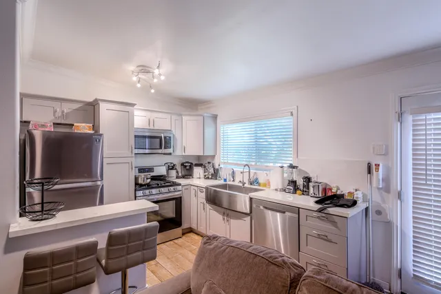 a kitchen that has a lot of cabinets in it and stainless steel appliances
