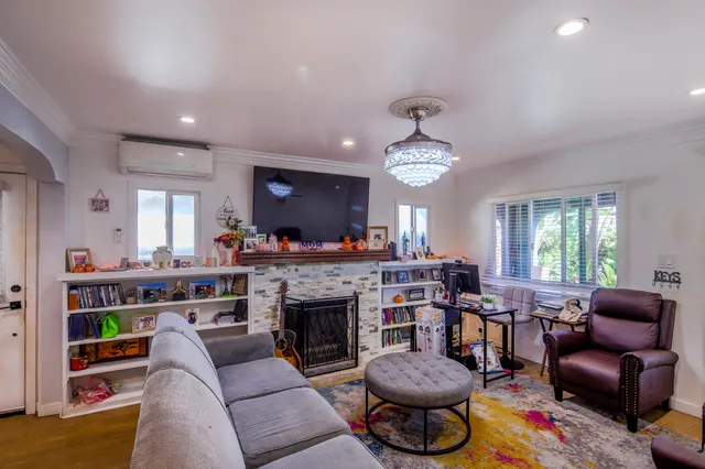 a living room with furniture a fireplace and a large window