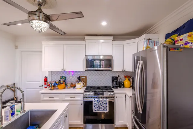 a kitchen with stainless steel appliances granite countertop a refrigerator a stove and a sink