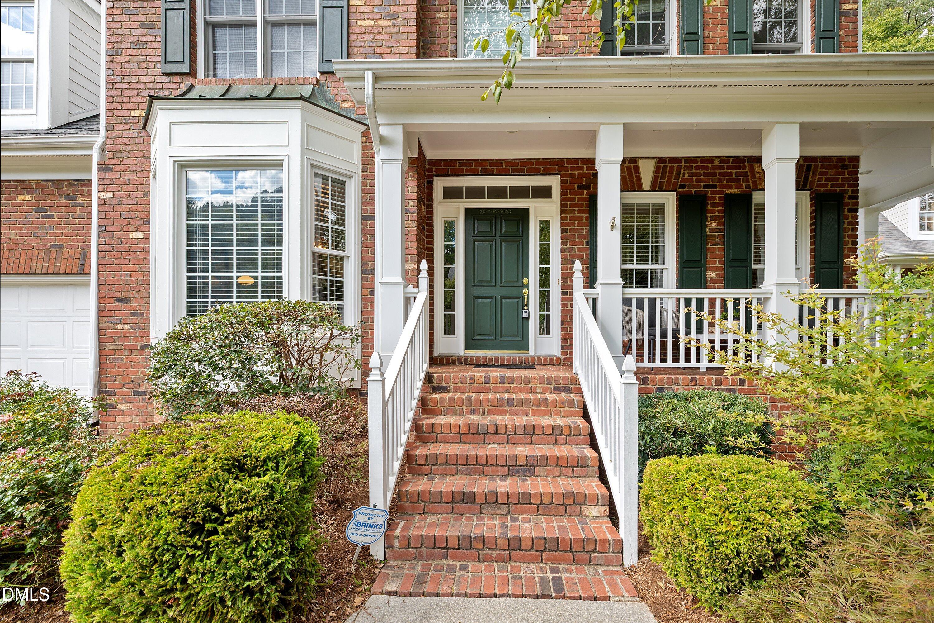3914 Sterling Ridge Lane Durham, NC 27707 - Photo 5 of 66 Brick exterior with a covered porch, bay window, and a green paneled entry door
