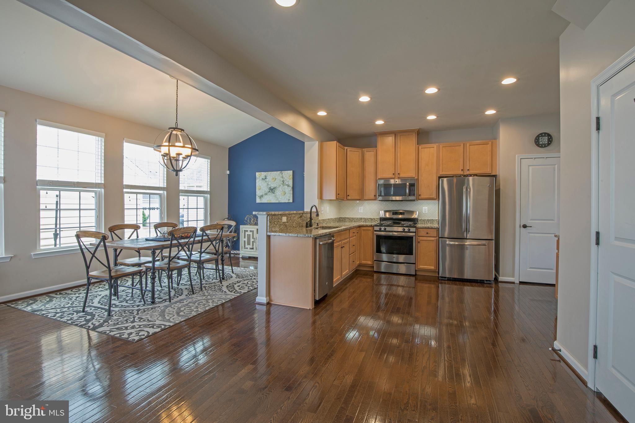 3713 Christopher Day Road Doylestown, PA 18902 - Photo 5 of 20 a kitchen with granite countertop a refrigerator a stove a dining table and chairs with wooden floor