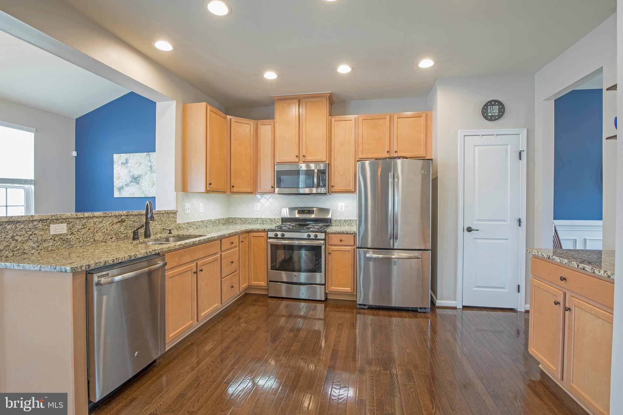 3713 Christopher Day Road Doylestown, PA 18902 - Photo 7 of 20 a kitchen with stainless steel appliances granite countertop a refrigerator a sink dishwasher a stove and white countertops with wooden floor