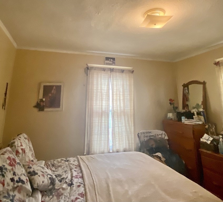 106-108 Maynard Street Springfield, MA 01109 - Photo 7 of 14 a bedroom with a bed and dresser with mirror