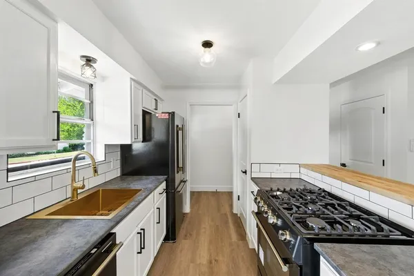 a kitchen with stainless steel appliances granite countertop a sink stove and refrigerator
