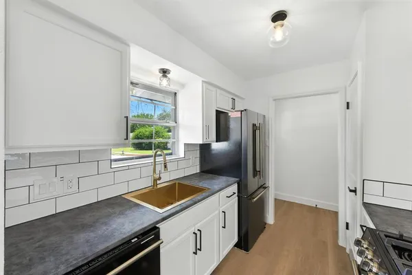 a kitchen with stainless steel appliances granite countertop a sink stove and refrigerator