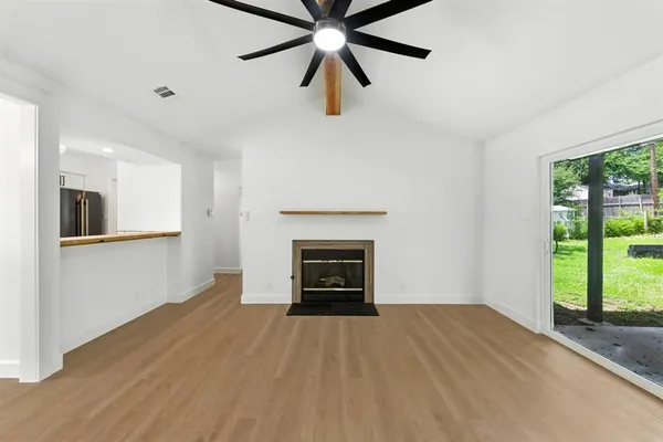 a view of empty room with wooden floor and fireplace