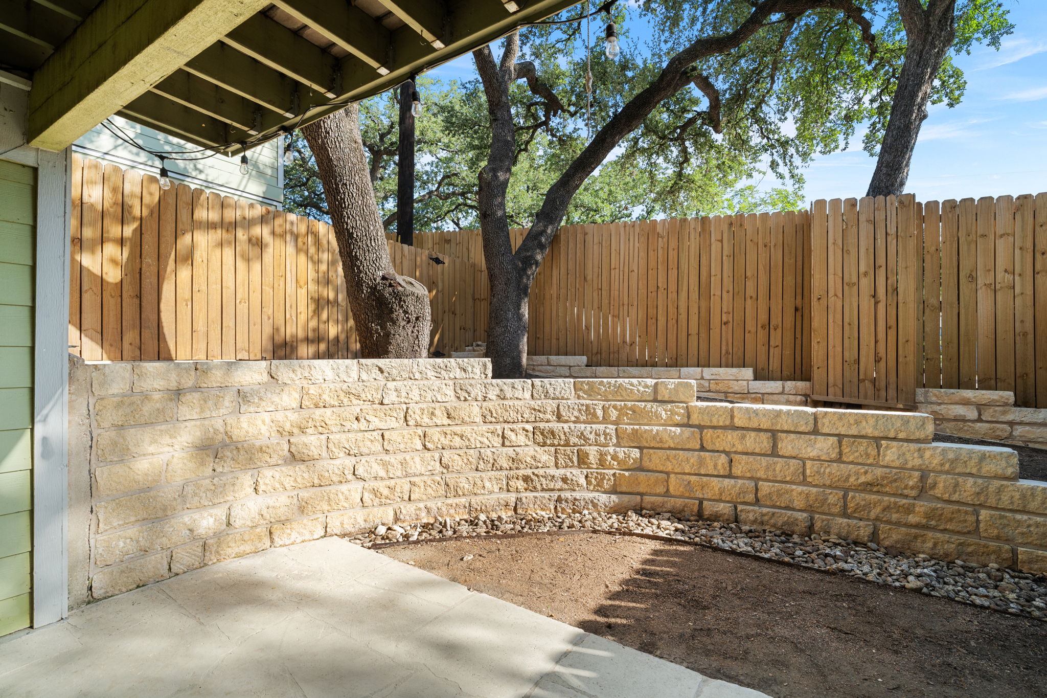 3601 Menchaca Road, Unit 110 Austin, TX 78704 - Photo 31 of 37 A private outdoor space with tiered stone retaining walls and a new wood fence.