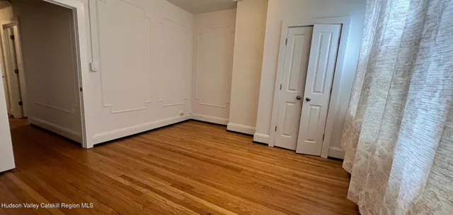 a backyard of a house with large trees and a wooden fence